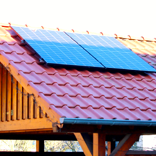 Dach mit roten Ziegeln und zwei Solarpanelen.